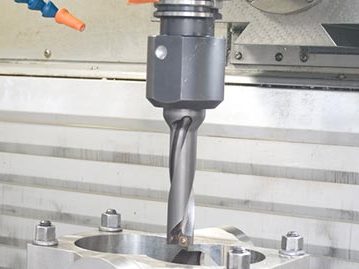 CNC-Fertigung Eine Präzisionsfräse schneidet ein Werkstück in einer Fertigungsanlage.